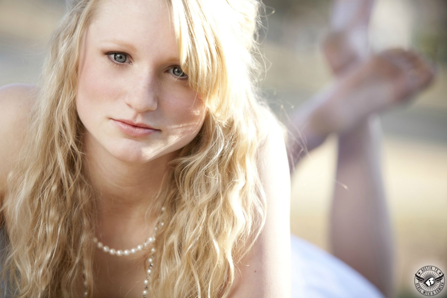 Austin senior portraits of blonde girl in white dress and pearls with hair and makeup by Divaz Fabula.